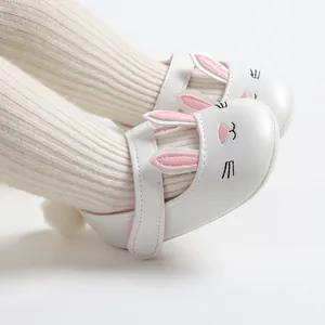 Close-up detail of white soft-sole baby princess shoes with adorable pink rabbit ears
