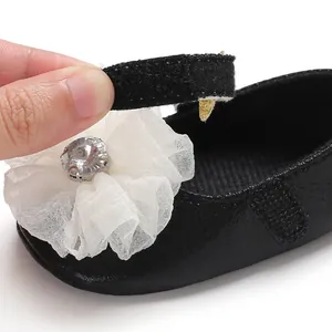 Detail of black baby girl princess shoe showing the adjustable velcro strap closure.