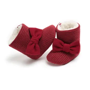 Close-up of red baby snow boots with knit bow and soft fleece lining