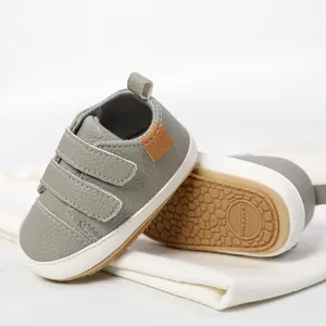 Close-up of grey leather baby walking shoes with soft soles and velcro straps