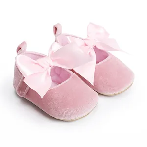Detail van roze fluwelen baby prinses loopschoentjes met grote elegante satijnen strikken