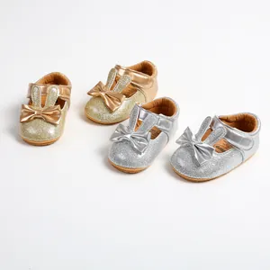 Detailed view of gold and silver glitter baby princess shoes with cute rabbit ears and bows.
