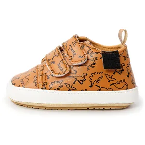 Detailed side view of brown baby walking shoes featuring a cute dinosaur print design