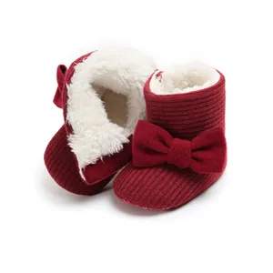 Cozy red knitted baby winter boots with soft fur lining and charming bow detail