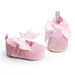 Gedetailleerde weergave van roze fluwelen baby prinses schoenen met grote satijnen strik