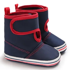 Detail view of navy blue infant soft-sole walking boots featuring red trim and striped sole
