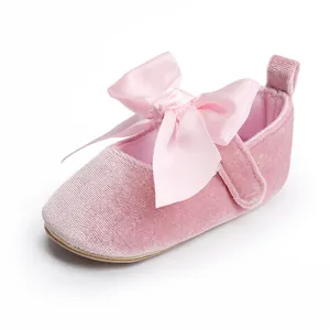 Gedetailleerd overzicht van de roze fluwelen baby prinsessenschoen met satijnen strik