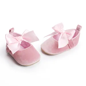 Detailopname van roze fluwelen baby prinsessenschoenen met satijnen strik en zachte zool