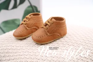 Close-up of brown PU leather baby walker shoes featuring classic decorative stitching