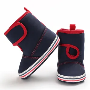 Detail view of navy blue and red soft-sole baby walking boots with velcro straps