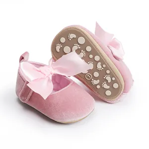 Gedetailleerd aanzicht van roze fluwelen baby prinsessenschoenen met een satijnen strik