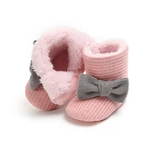 Soft pink knitted baby snow boots with fluffy faux fur lining and elegant gray bow.