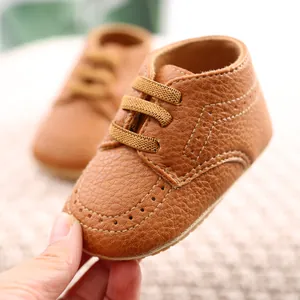 Close-up detail of brown PU leather baby walking shoes with soft soles and stitching
