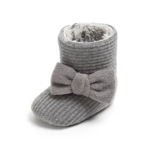 Detailed view of a grey knit baby winter boot featuring a large bow and soft lining