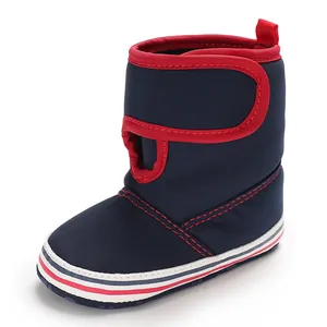 Detailed view of navy blue baby boot with red trim and velcro strap for toddlers