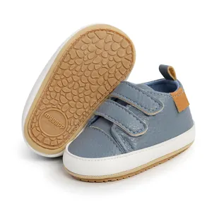 Close-up detail of blue infant walking shoes featuring double velcro straps and non-slip sole