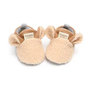 Close-up of beige fleece baby shoes with cute cartoon ears and soft soles