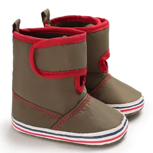 Close-up detail of olive green soft sole baby boots with red trim and velcro straps