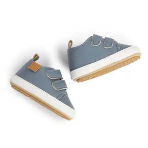 Detailed view of blue baby walking shoes with Velcro straps and soft white soles