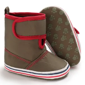 Detail of soft sole baby pre-walker boots in green and red with paw print sole