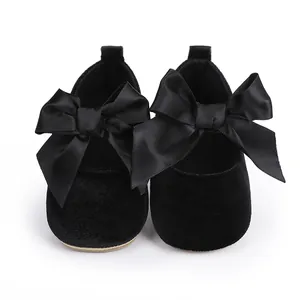 Detailopname van elegante zwarte fluwelen baby prinsesschoenen met grote satijnen strik