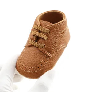 Close-up of a small brown PU leather baby loafer with a soft sole and elastic laces.