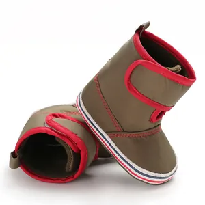 Macro view showing the soft fabric and red trim of these olive green baby walking boots