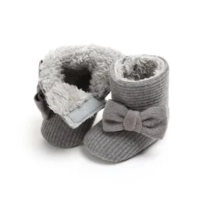 Close-up of grey baby winter boots with soft faux fur lining and cute bow detail.