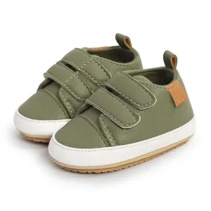 Close-up of olive green infant walking shoes with double velcro straps and white soles