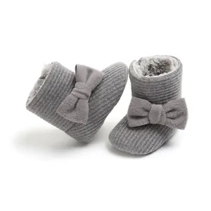 Soft grey knitted baby snow boots with a plush lining and large bow decoration