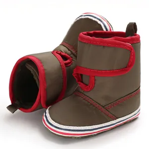 Detailed side view of olive green baby walking boots with soft soles and red trim
