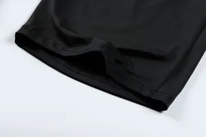 Close-up showing the precise double-stitched hem of black quick-dry men's athletic shorts.