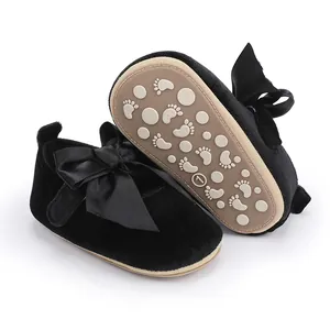 Gedetailleerde weergave van zwarte fluwelen baby prinsessenschoenen met grote strik