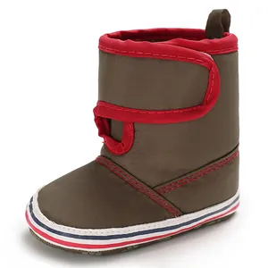Detailed side view of a brown baby walking boot featuring a soft sole and red trim