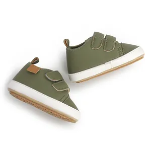 Detailed view of olive green baby walking shoes with velcro straps and white soles