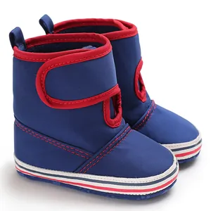 Detailed side view of blue baby walking boots featuring soft soles and red trim accents