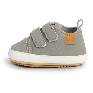 Close-up detail of grey faux leather baby walking shoe with double velcro straps