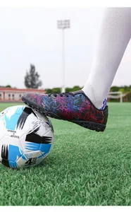 Gros plan d'une chaussure de foot au motif éclair sur un terrain de gazon vert