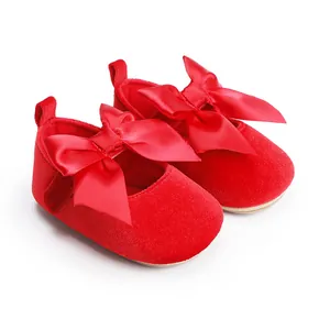 Detailweergave van elegante rode fluwelen baby prinsessenschoenen met grote satijnen strik