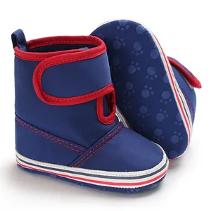 Detailed view of blue canvas baby boots with red trim and anti-slip paw print sole