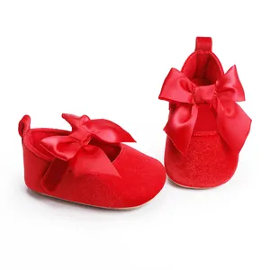 Detail van zachte rode fluwelen baby prinsessenschoenen met een grote satijnen strik