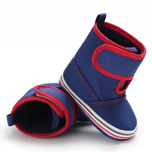 Detailed side view of navy blue baby boots with soft soles and red trim for infant toddlers