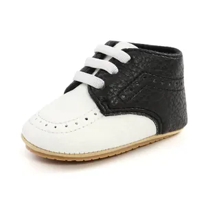 Detailed side view of black and white infant soft sole walker shoe with decorative holes