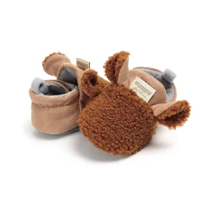 Close-up of brown plush cartoon baby winter shoes with soft warm fleece lining detail