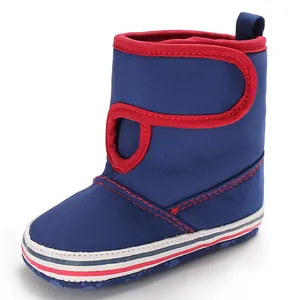 Detailed side view of navy blue baby walking boots with red trim and soft striped sole