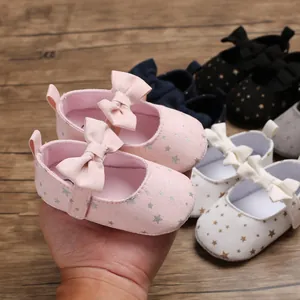 Detailansicht von rosa Baby-Prinzessin-Schuhen mit Schleife und silbernen Sternmustern