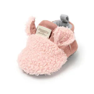 Close-up of pink baby winter bootie with soft fleece texture and cute ears