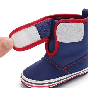 Close-up detail of the white hook-and-loop fastener on a navy blue soft sole baby boot