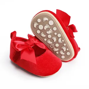 Detailweergave van rode fluwelen baby prinsessenschoenen met strik en een antislipzool