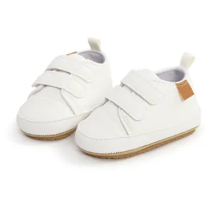 Detailed view of white infant walking shoes with double hook-and-loop straps